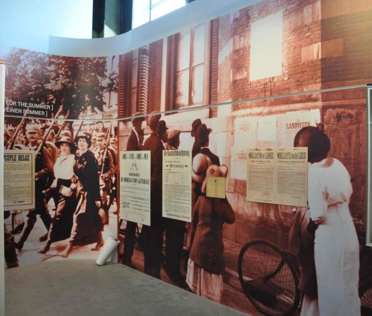 Mur d'exposition en vinyle imprimé représentant une scène historique avec des affiches de mobilisation, utilisé dans le musée de la Grande Guerre de Meaux.