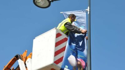 Installation drapeau publicitaire extérieur nacelle élévatrice poseur professionnel gilet sécurité