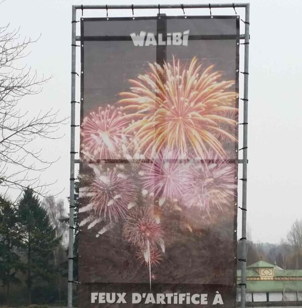 Bâche grand format micro perforée sur structure en tubes pour évènement dans un parc d'attraction Walibi, impression couleur haute définition d'un feux d'artifice pour endroits venteux.