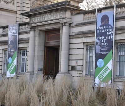 Bâche publicitaire grand format avec œillets pour exposition de musée, impression haute qualité extérieur résistant sur une structure tubulaire.