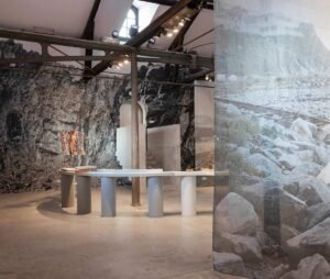 Impression grand format sur papier Blueback – Mur décoratif pour espaces d’exposition Mur d’exposition recouvert d’une impression grand format sur papier Blueback représentant un paysage rocheux montagneux, dans un espace muséal.