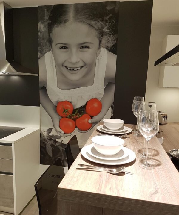 Toile murale imprimée en une seule pièce, représentant une fillette tenant des tomates, installée comme élément décoratif lors de Batibouw