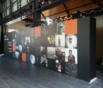 Mur d’exposition imprimé en grand format sur toile murale sans joint, composé d’un collage de photographies de mineurs du monde entier, aux Bois du casier.