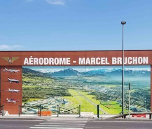 Fresque murale panoramique imprimée sur panneaux de stratifié HPL et installée sur la façade d’un aérodrome.