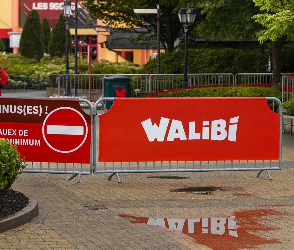 Barrières Nadar équipées de bâches imprimées grand format Walibi à l’entrée du parc pour le covid, installation extérieure résistante et personnalisée.