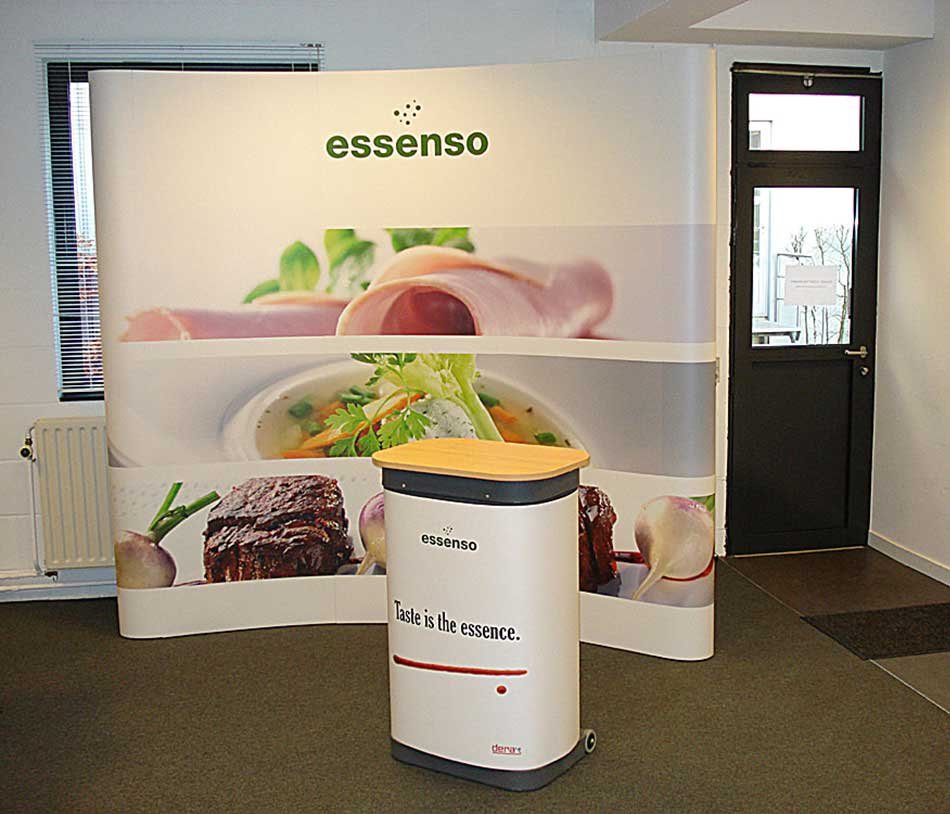 Mur Pop-Up incurvé Essenso avec comptoir d'accueil impression grand format pour stand salon professionnel B2B