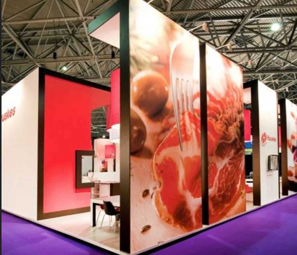 Stand d’exposition équipé de grands panneaux en tissu imprimé tendu, utilisés comme habillage visuel et arrière-plan décoratif sur structure autoportante.