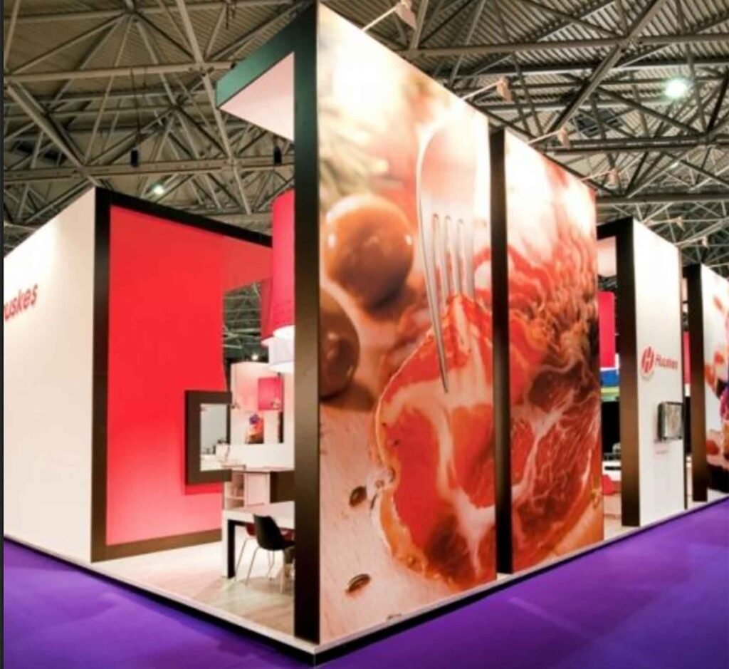 Stand d’exposition équipé de grands panneaux en tissu imprimé tendu, utilisés comme habillage visuel et arrière-plan décoratif sur structure autoportante.