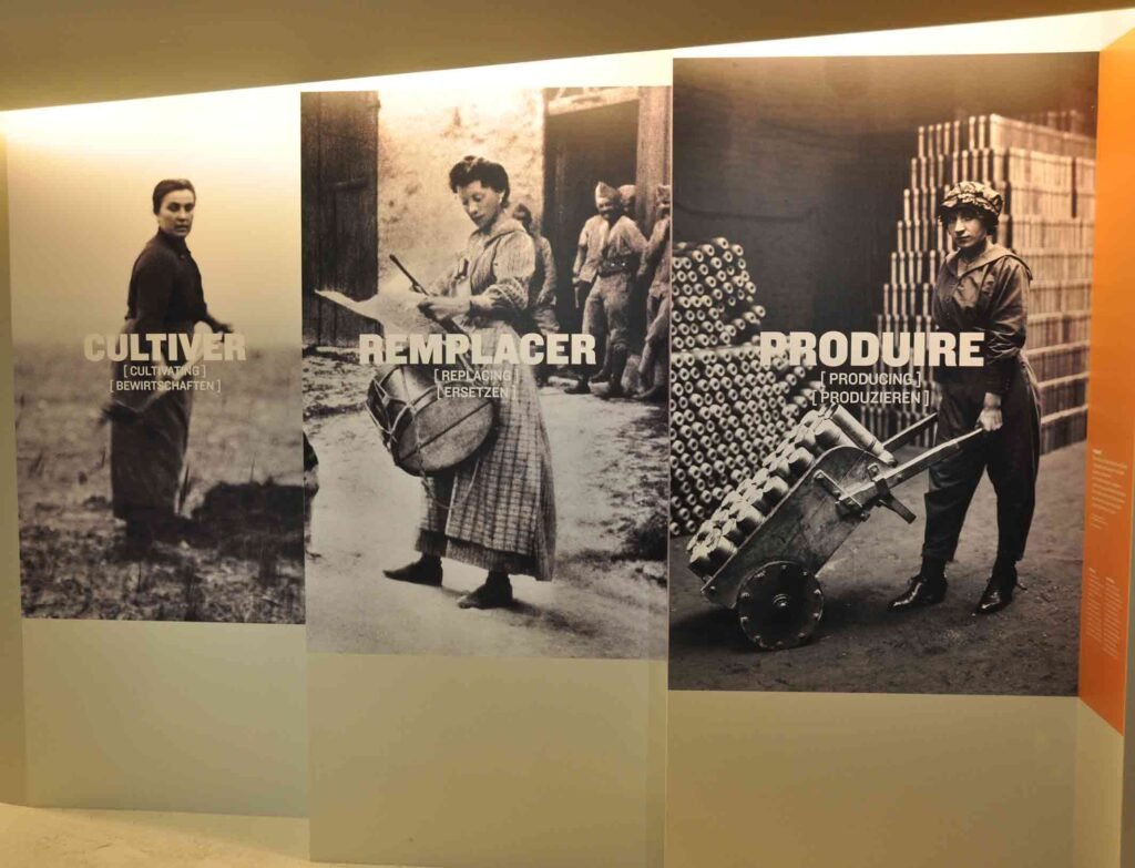 Impression grand format sur vinyle permanent avec visuels historiques des femmes pendant la guerre 40-45 en noir et blanc installés sur un mur d’exposition.